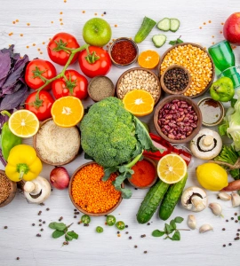 Colorful fresh vegetables, fruits, legumes, and grains arranged flat lay overhead view