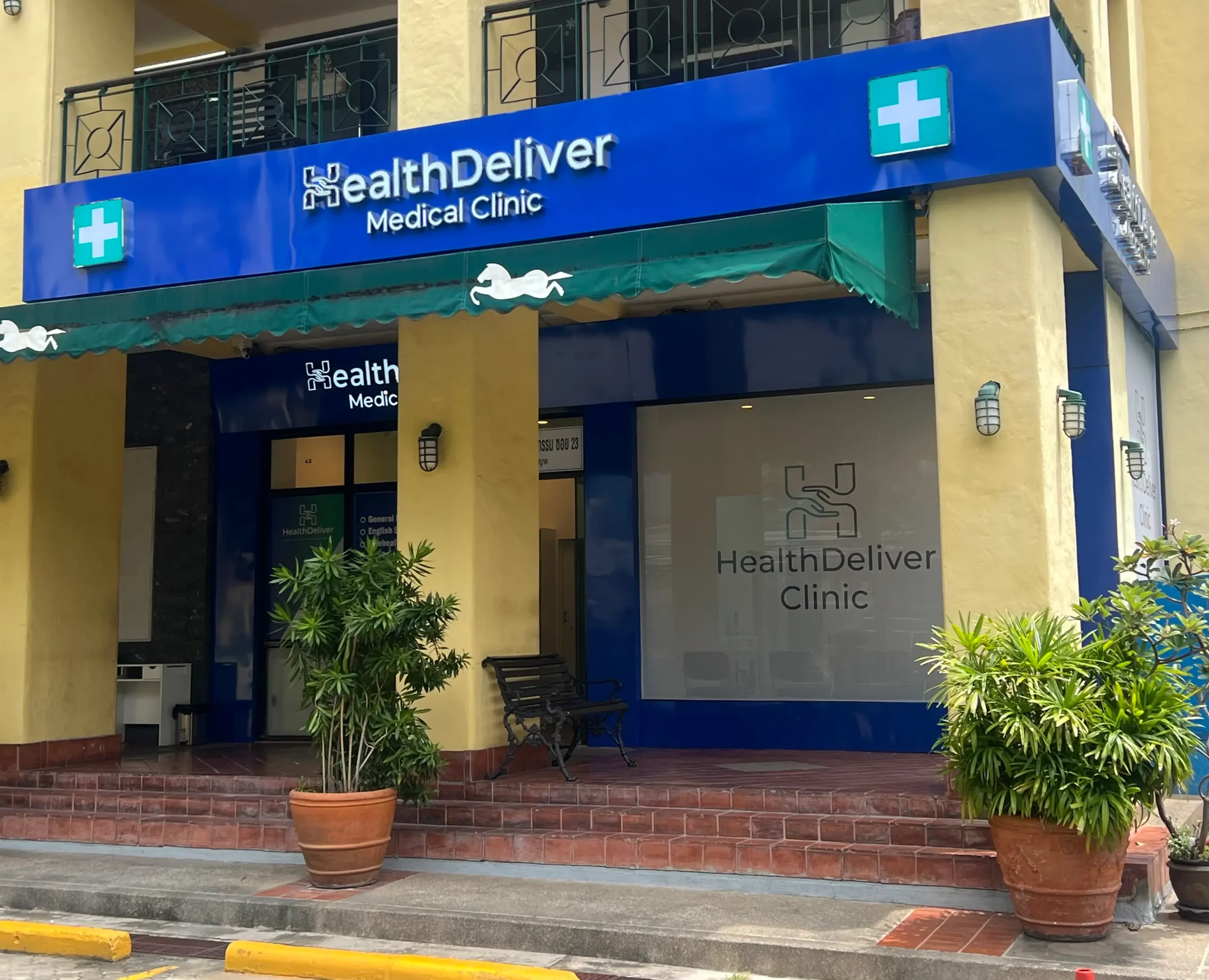 HealthDeliver Medical Clinic storefront with blue signage and plants